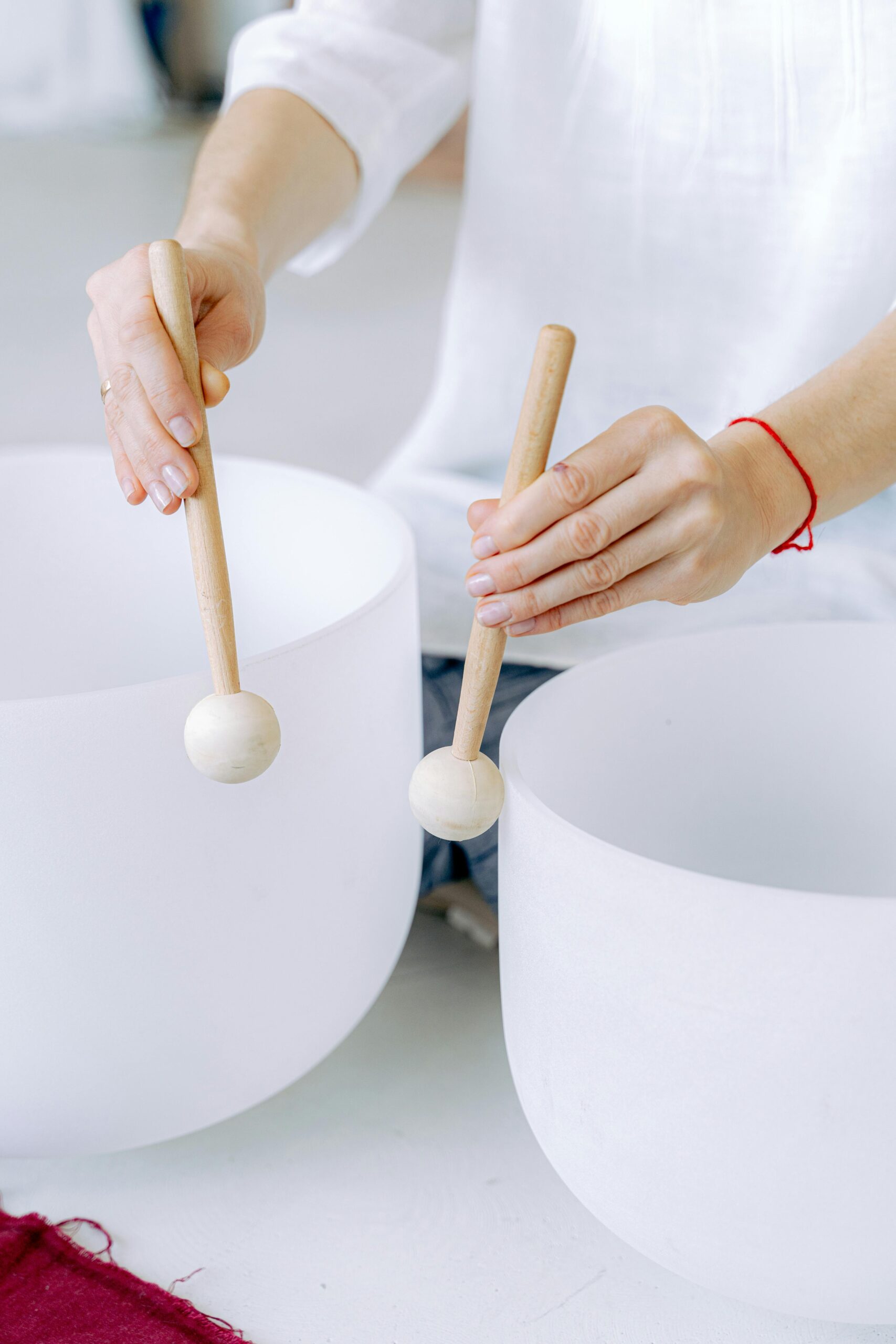 Hands gently playing crystal singing bowls for a soothing sound bath experience.
